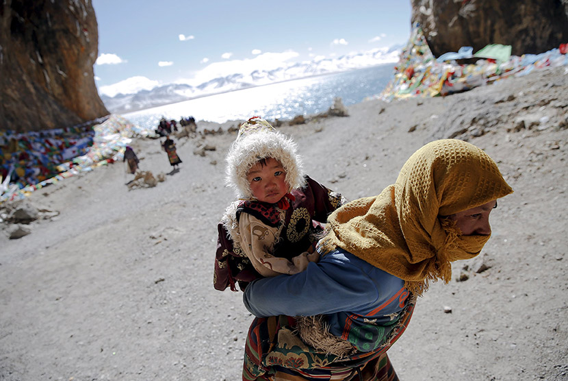  Seorang wanita Tibet menggendong anaknya.  (Reuters/Damir Sagolj)