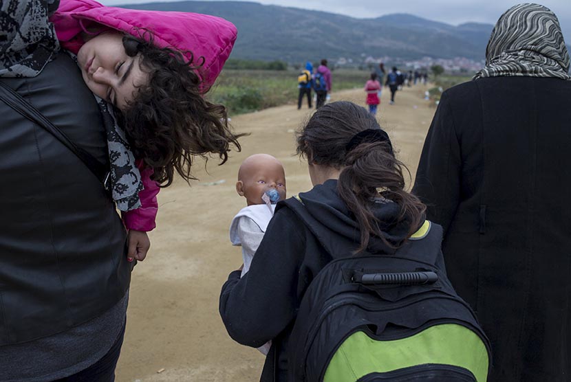  Anak-anak pengungsi Suriah berjalan bersama keluarganya. (REUTERS/Marko Djurica)  