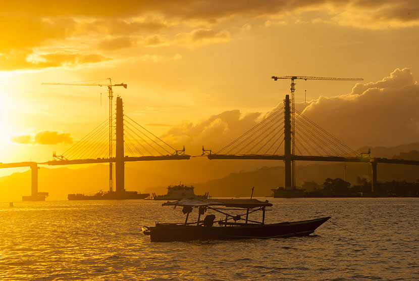 Panorama senja terakhir tahun 2015 di Teluk Ambon dengan latar belakang pembangunan Jembatan Merah Putih, Ambon, Maluku, Kamis (31/12).  (Antara/Embong Salampessy)