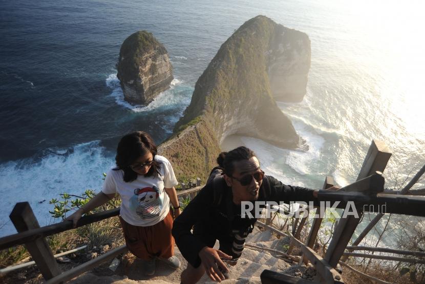 Wisatawan menyusuri anak tangga di Pantai Kelingking, Nusa Penida, Klungkung, Bali, Minggu (6/10/2019).
