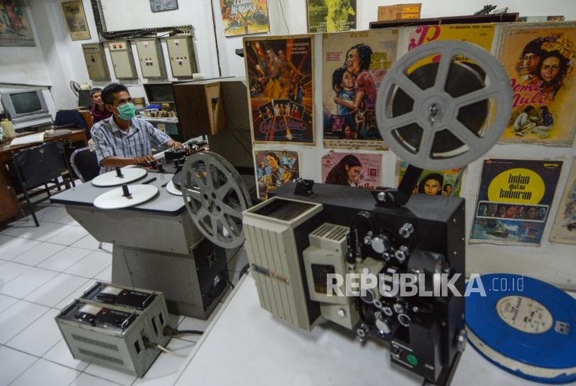 Firdaus (47) membersihkan film seloluid di gudang perawatan film Indonesia Gedung Pusat Perfilman H. Usmar Ismail,  Jalan HR Rasuna Said, Jakarta.
