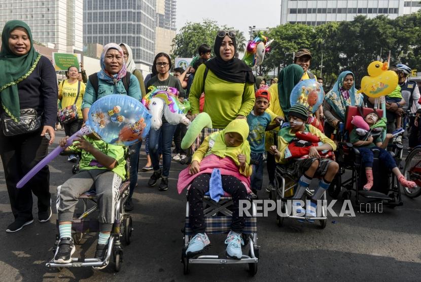 Sejumlah anak-anak penyandang cerebral palsy beserta orang tua dan aktivis berjalan mengikuti kegiatan peringatan hari Cerebral Palsy di kawasan Bundaran HI, Jakarta, Ahad (13/10/2019). Anak cerebral palsy sebagian ada yang bisa hidup mandiri.