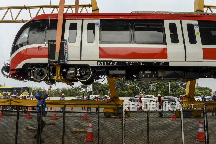 Pekerja melihat proses pengangkatan kepala gerbong kereta layang ringan atau LRT ke atas rel di Stasiun Harjamukti, Depok, Jawa Barat, Ahad (13/10).