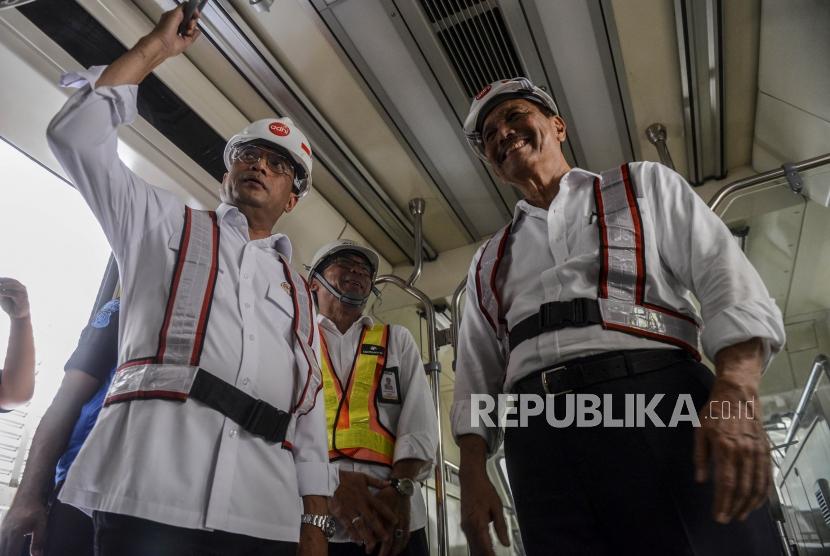 Menteri Koordinator Bidang Kemaritiman Luhut Binsar Panjaitan (kanan) dan Menteri Perhubungan Budi Karya Sumadi (kiri) saat meninjau bagian dalam gerbong LRT di Stasiun Harjamukti, Depok, Jawa Barat, Ahad (13/10).