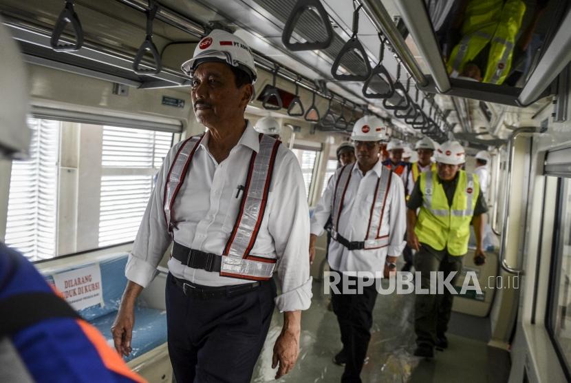 Menteri Koordinator Bidang Kemaritiman Luhut Binsar Panjaitan (kiri) dan Menteri Perhubungan Budi Karya Sumadi (tengah) saat meninjau bagian dalam gerbong LRT di Stasiun Harjamukti, Depok, Jawa Barat, Ahad (13/10).