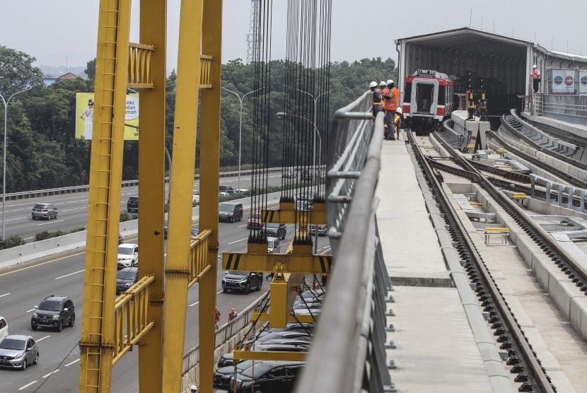 Sejumlah karyawan mengecek keadaan rel dan gerbong kereta layang ringan atau LRT di Stasiun Harjamukti, Depok, Jawa Barat, Minggu (13/10/2019).