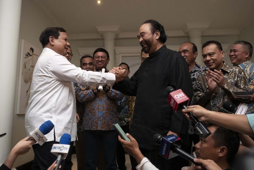 Ketua Umum Partai Gerindra Prabowo Subianto (kiri) berjabat tangan dengan Ketua Umum Partai NasDem Surya Paloh (tengah) usai melakukan pertemuan di kawasan Permata Hijau, Jakarta, Ahad (13/10/2019).