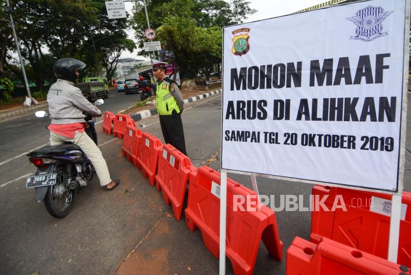Anggota Kepolisian mengatur lalu lintas saat dilakukan penutupan jalur dikawasan Gedung DPR RI Senayan, Jalan Gatot Soebroto, Jakarta, Jumat (18/10/2019).