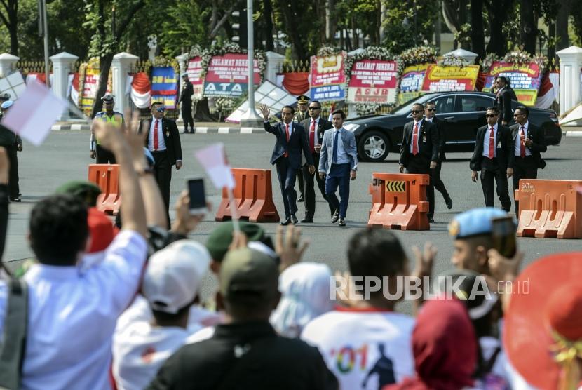 Presiden Terpilih Periode 2019-2024 Joko Widodo menghampiri relawan sebelum menuju ke tempat pelantikan di Jakarta, Ahad (20/10).