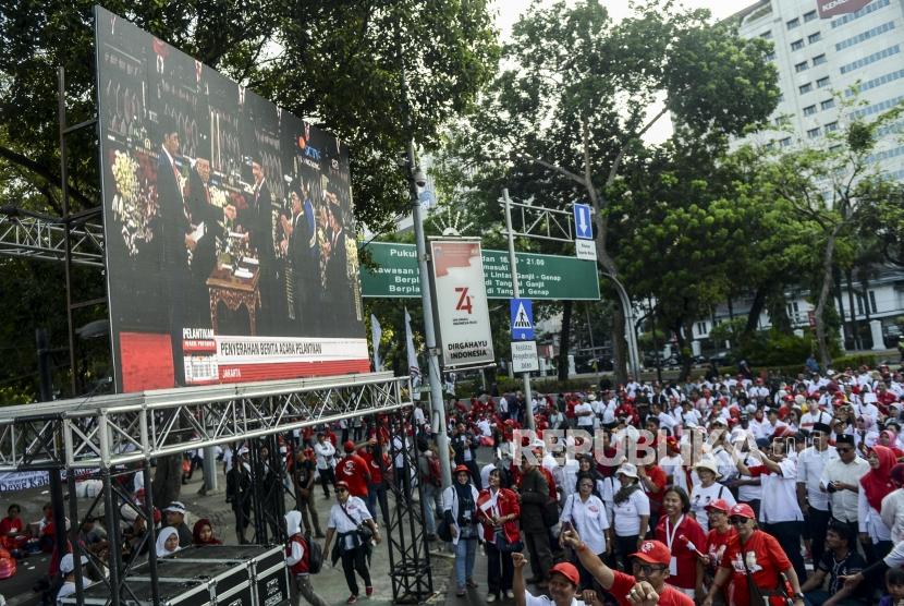Relawan saat nonton bareng pidato Presiden Republik Indonesia periode 2019-2024, Joko Widodo di depan Istana Merdeka, Jakarta, Ahad, (20/10).