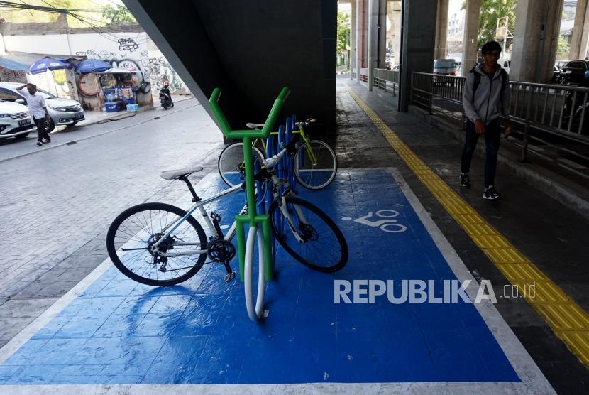 Warga melintas disamping sepeda yang terparkir di Parkir Sepeda Stasiun MRT Cipete Raya, Jakarta, Senin (21/10).