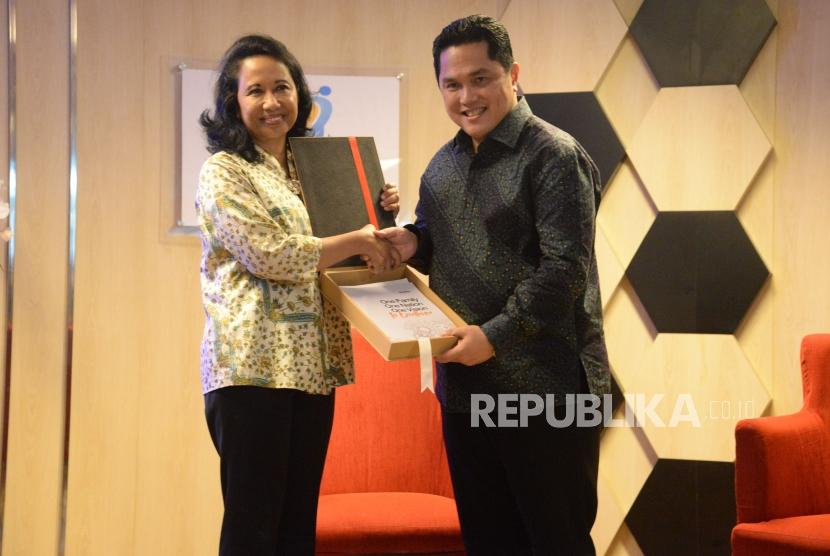 Mantan Menteri BUMN Rini Soemarno memberikan buku laporan kinerja kepada Menteri BUMN Erick Thohir pada acara serah terima jabatan di Kementerian BUMN, Jakarta, Rabu (23/10).