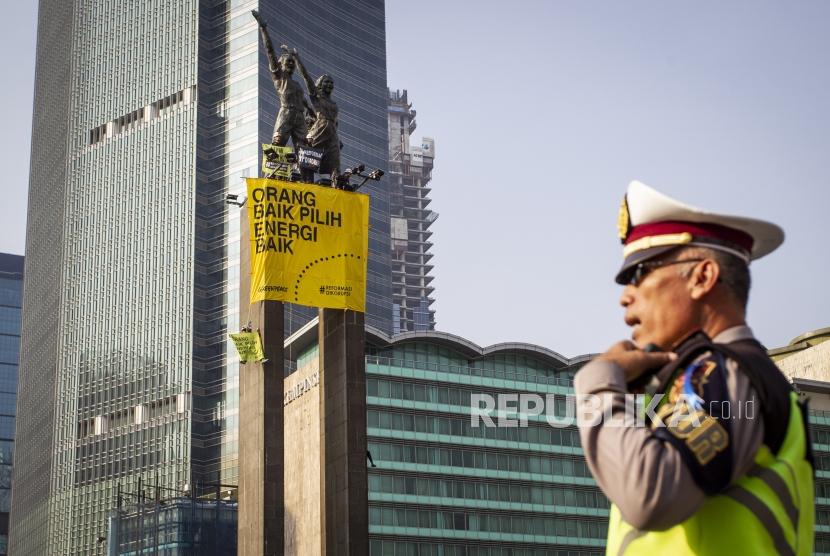 Aktivis Greenpeace membentangkan spanduk saat menggelar aksi di Monumen Selamat Datang, Bundaran HI, Jakarta, Rabu (23/10/2019).