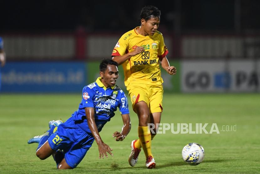 Pesepak bola Bhayangkara FC Adam Alis Setyano (kanan) berebut bola dengan pesepak bola Persib Bandung Frets Listanto Butuan (kiri) dalam lanjutan Liga 1 Indonesia di Stadion PTIK, Jakarta, Rabu (23/10/2019).