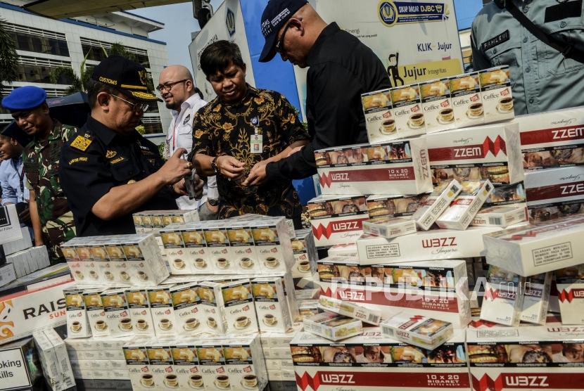 Petugas melihat rokok hasil penindakan barang kena cukai saat konferensi pers di Jakarta, Jumat (25/10).