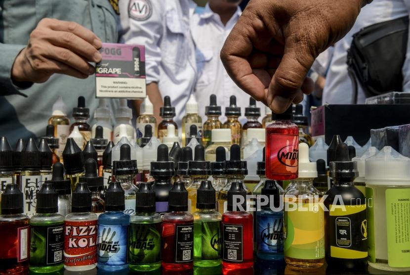 Petugas memperlihatkan liquid rokok elektrik hasil penindakan barang kena cukai saat konferensi pers di Jakarta, Jumat (25/10).