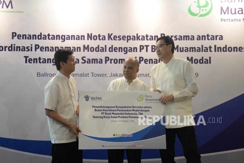Chief Executive Officer Bank Muamalat Achmad K.Permana (kanan) dan Komisaris Utama Bank Muamalat Ilham Akbar Habibie (tengah)  berbincang bersama Deputi Kepala Bidang Kerjasama Penanaman Modal BKPM Wisnu Wijaya Soedibjo (kiri) usai melakukan penandatanganan kerjasama di Jakarta, Jumat (25/10).