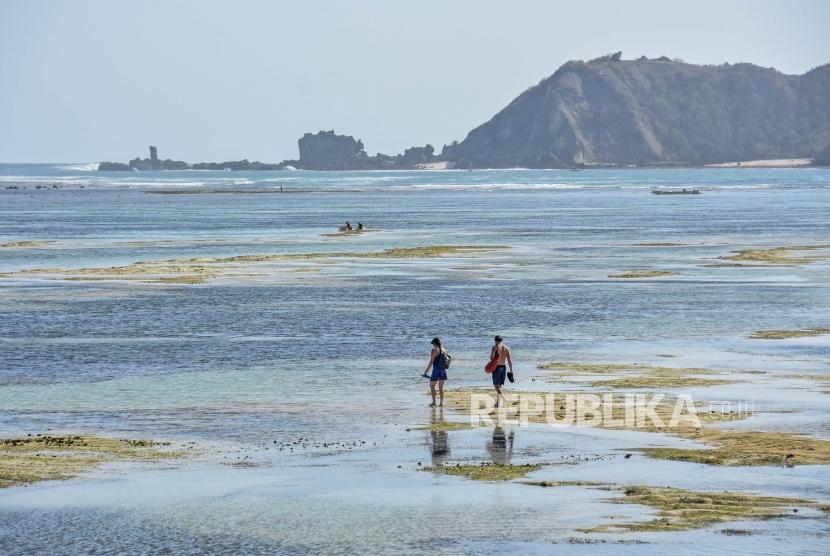 Wisatawan mancanegara berjalan saat air surut di pantai Mandalika, Desa Kuta, Kecamatan Pujut, Praya, Lombok Tengah, NTB. Lombok menjadi salah satu dari lima destinasi wisata favorit turis Singapura dan Malaysia.
