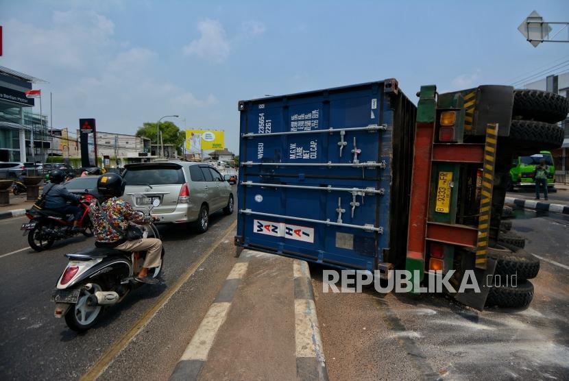 Sejumlah warga melintas disamping truk kontainer yang mengalami kecelakaan di Jalan Sultan Agung, Kranji, Bekasi, Jawa Barat, Kamis (31/10/2019).