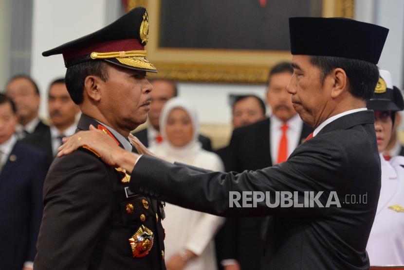 Presiden Joko Widodo menyematkan bintang jabatan kepada Kapolri Jenderal Idham Aziz saat pelantikan di Istana Merdeka, Jakarta, Jumat (1/10).