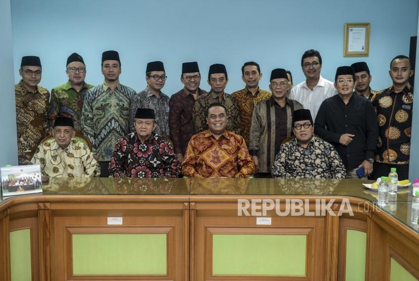 Wakil Ketua Dewan Masjid Indonesia Syafruddin (kedua kanan depan) bersama Sekjen MUI Anwar Abbas (kedua kiri depan) dan Pemimpin Redaksi Republika Irfan Junaedi (kiri) foto bersama usai kunjungan ke Kantor MUI, Jakarta, Jumat (1/11).