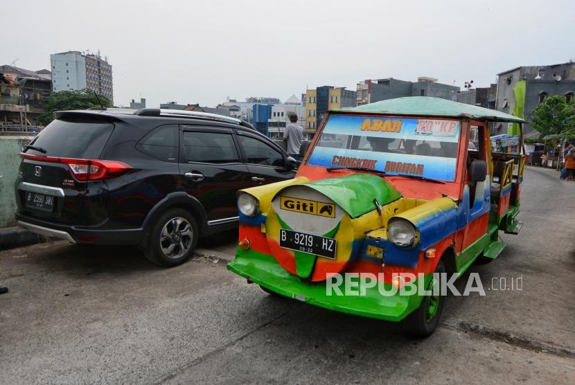 Sejumlah penumpang menaiki kendaraan odong-odong di kawasan Kampung Pulo, Jakarta, Jumat (1/11/2019).