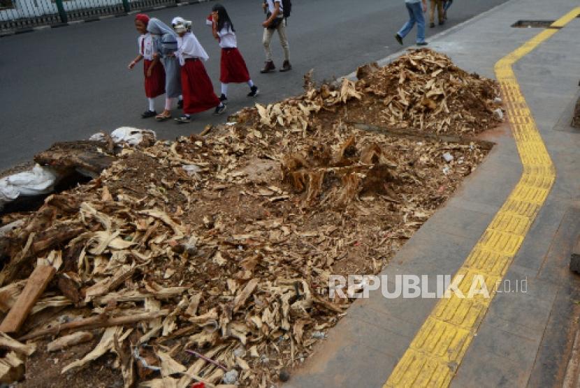 Pejalan kaki melintas di lahan bekas penebangan pohon di trotoar Cikini, Jalan Cikini Raya, Jakarta, Senin (4/11/2019).