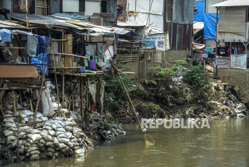 Warga mencari sampah plastik yang mengalir dari sungai di kawasan pemukiman kumuh di Manggarai, Jakarta, Selasa (5/11).