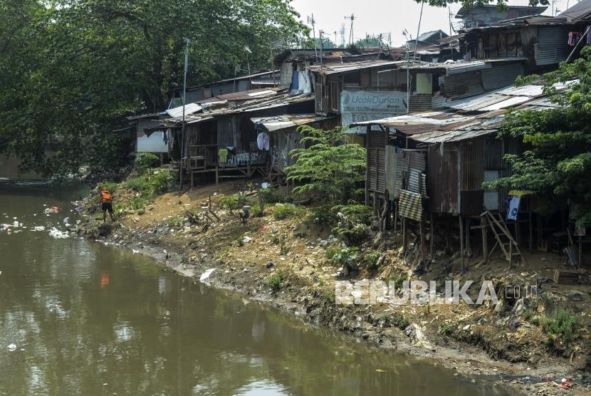 Seorang warga membersihkan sampah di dekat pemukiman kumuh di kawasan Manggarai, Jakarta, Selasa (5/11). Center of Reform on Economics (CORE) Indonesia memperkirakan, jumlah penduduk di bawah garis kemiskinan berpotensi bertambah 5,1 juta sampai 12,3 juta orang pada kuartal kedua 2020. 