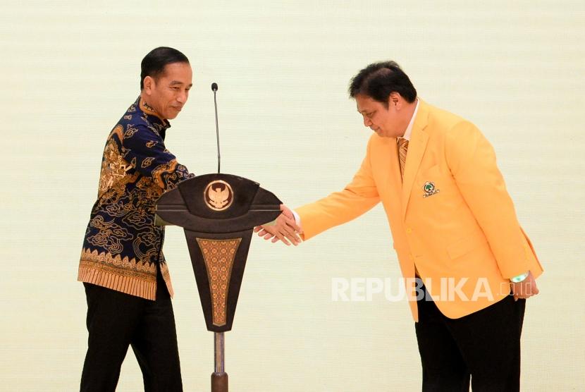 Presiden Joko Widodo bersalaman dengan Ketua Umum Partai Golkar Airlangga Hartarto saat peringatan HUT ke-55 tahun Partai Golkar di Jakarta, Rabu (6/11).