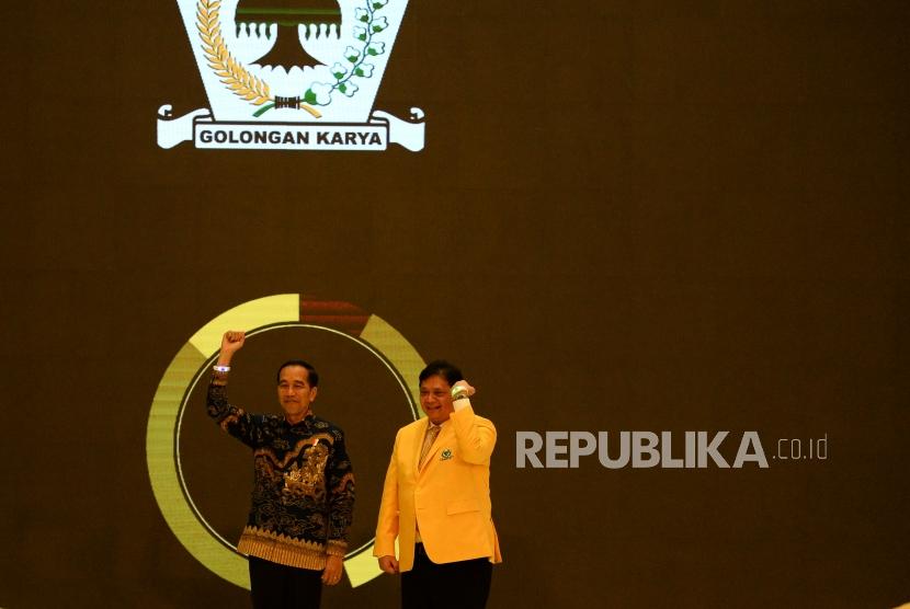 Presiden Joko Widodo bersama Ketua Umum Partai Golkar Airlangga Hartarto mengangkat tangan saat memperingati HUT ke-55 tahun Partai Golkar di Jakarta, Rabu (6/11).