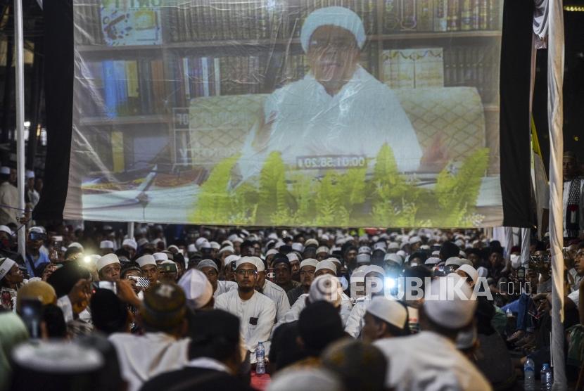 Sejumlah jamaah saat mendengar ceramah dari Ketua Front Pembela Islam (FPI) Habib Rizieq Shihab pada acara Maulid Akbar Nabi Besar Muhammad SAW ke 1493 di Jalan KS Tubun, Jakarta, Jumat (9/11).