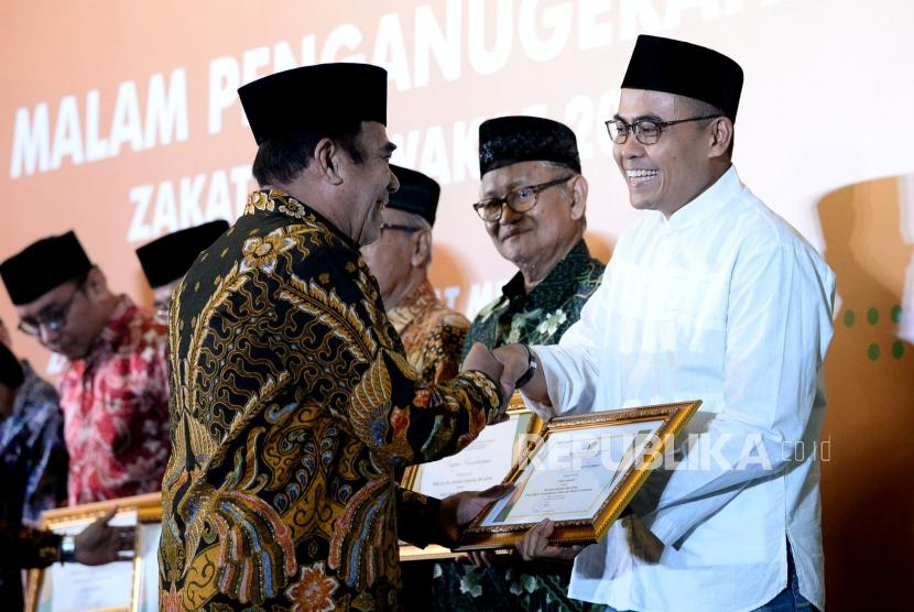 Menteri Agama Fachrul Razi memberikan penghargaan kepada Pemimpin Redaksi Republika Irfan Junaedi dalam malam penganugerahan Zakat dan Wakaf 2019 di Jakarta, Ahad (10/11).