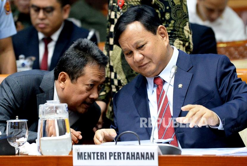 Menteri Pertahanan Prabowo Subianto berbincang dengan Wakil Menteri Pertahanan Wahyu Sakti Trenggono sebelum mengikuti rapat kerja dengan Komisi I DPR di Kompleks Parlemen Senayan, Jakarta, Senin (11/11).