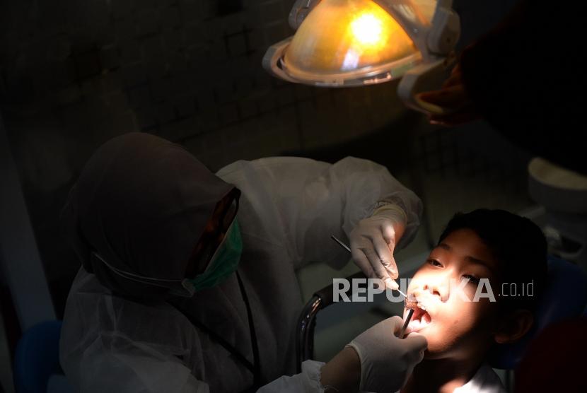  Dokter memeriksa gigi anak.