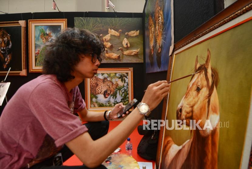 Pengunjung mengamati karya seni lukis pada gelaran  Indonesia Art Festival di Museum Nasional, Jakarta, Senin (11/11/2019).