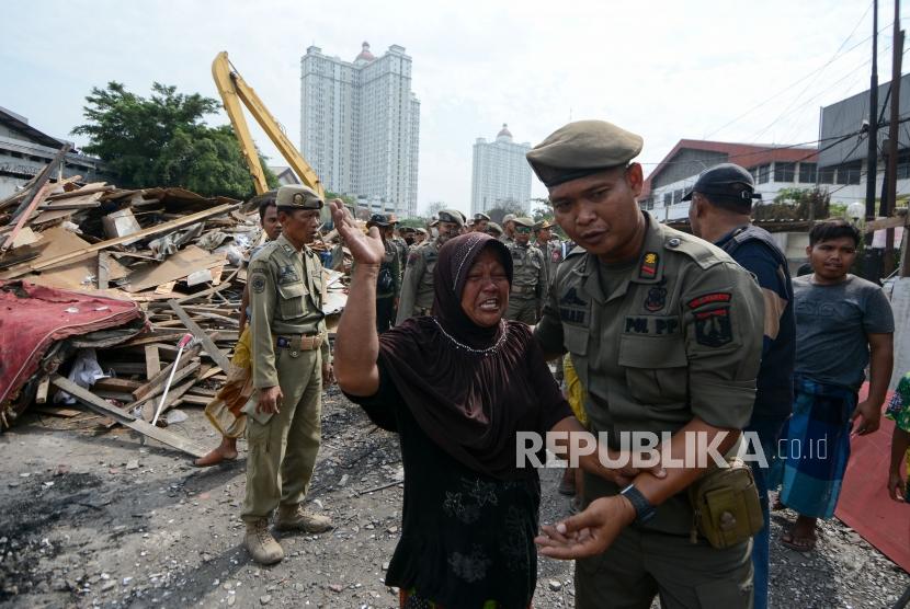 Petugas Satuan Polisi Pamong Praja menenangkan warga yang melakukan penolakan penggusuran rumah semi permanan kawasan Sunter, Jalan Agung Sunter Perkasa VIII, Jakarta, Senin (18/11).