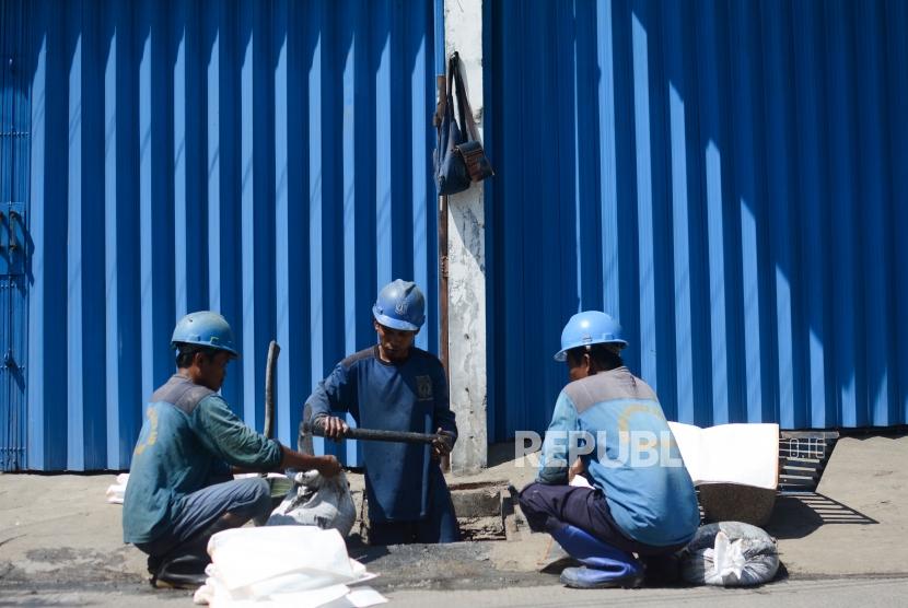 Petugas Suku Dinas Tata Air membersihkan gorong-gorong di Jalan Jelambar Selatan, Jakarta Barat, Selasa (19/11).