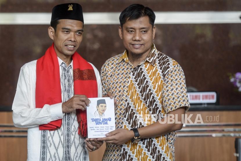 Ustaz Abdul Somad memberikan buku karangannya usai memberikan kajian tausiyah di Gedung KPK, Jakarta, Selasa (19/11).