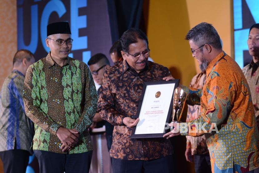 Menteri ATR/ Kepala BPN Sofyan Djalil, menyerahkan penghargaan kepada perwakilan BNI Syariah pada malam  Anugerah Syariah Republika 2019 di Hotel JW Mariott Jakarta, Selasa (19/11).