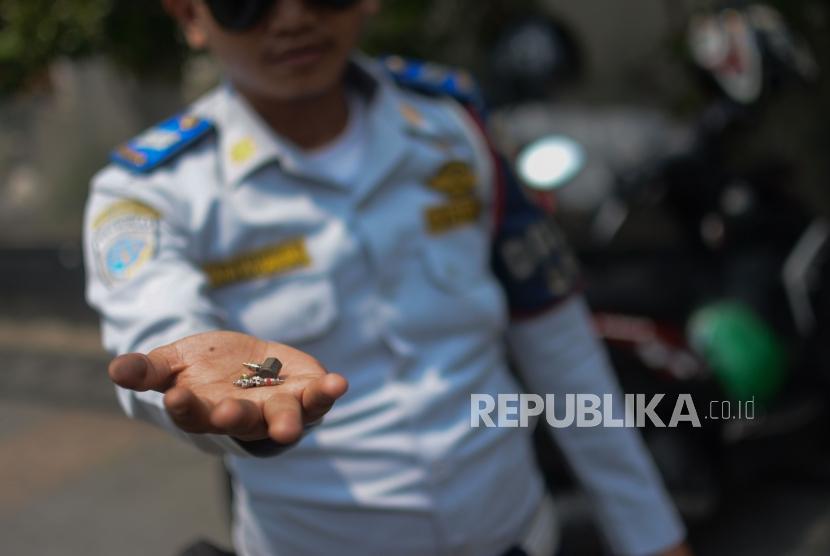 Petugas Dinas Perhubungan (Dishub)  DKI Jakarta melakukan penindakan terhadap pengendara yang memarkirkan motor di trotoar di kawasan Sudirman, Jakarta, Jumat (22/11).