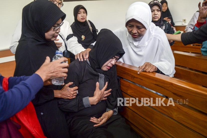 Salah satu korban First Travel, Sri Nurwati (tengah) pingsan usai sidang gugatan perdata First Travel di Pengadilan Negeri Depok, Jawa Barat, Senin (25/11).