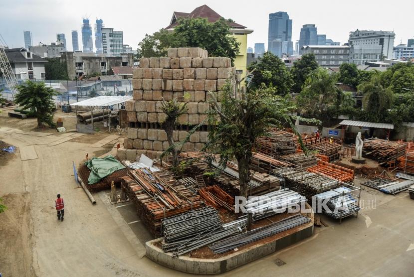 Pekerja melintas di area proyek revitalisasi kawasan Taman Ismail Marzuki (TIM) di Jakarta, Selasa (26/11).