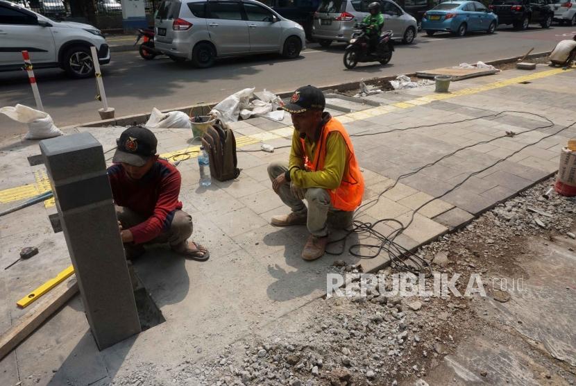 Pekerja mengerjakan proyek revitalisasi trotoar di Kawasan Kemang, Jakarta Selatan