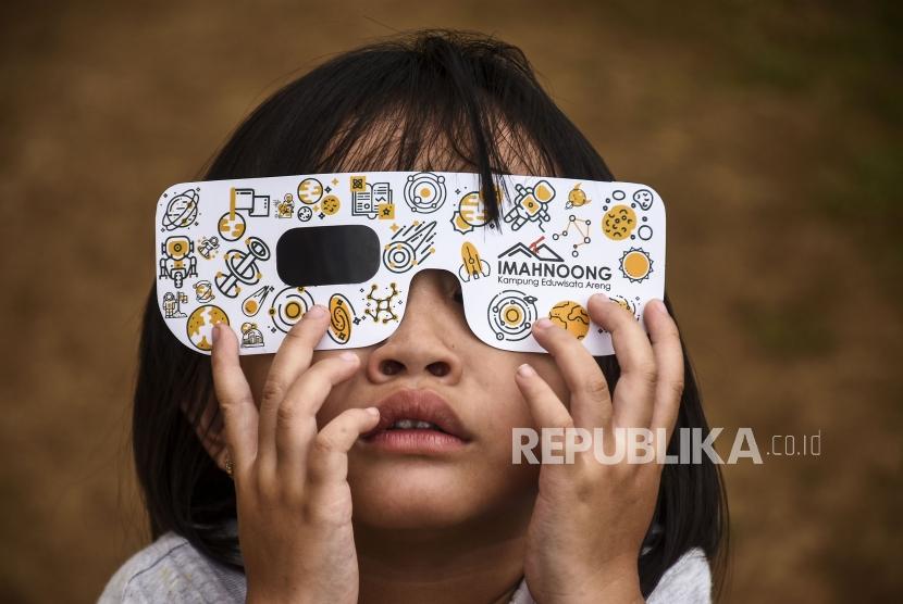 UMSU akan menyiapkan 3.000 kacamata untuk mengamati gerhana matahari cincin. Foto: Seorang anak mencoba kacamata untuk melihat gerhana matahari cincin di Imah Noong, Kecamatan Lembang, Kabupaten Bandung Barat, Rabu (27/11).
