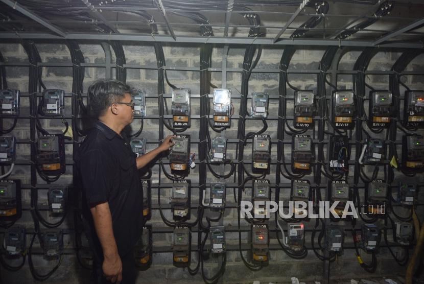 Petugas PLN memeriksa meteran listrik di rumah pelanggan. ilustrasi