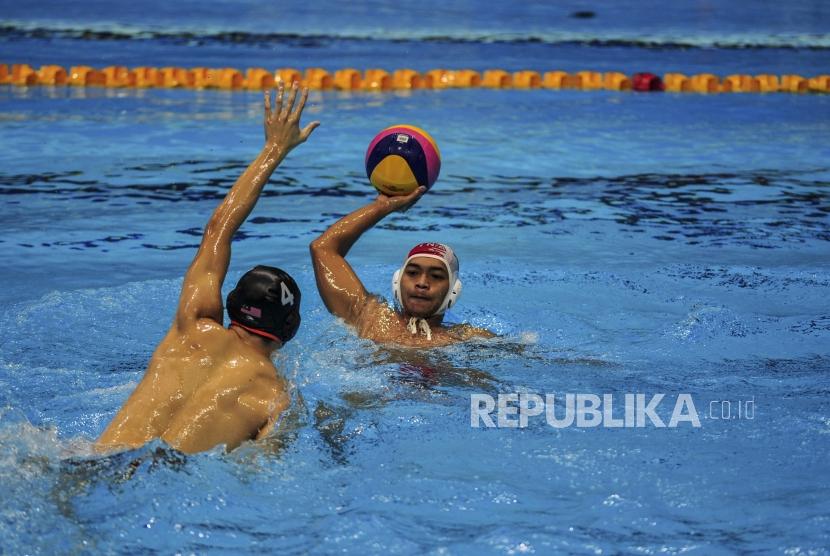 Pemain polo air Indonesia Rian Rinaldo (kana) dihalangi pemain polo air Malaysia Yi Xiang Toh saat akan melempar bola di New Clark City Aquatic Centre, Clark, Filipina, Jumat (29/11).