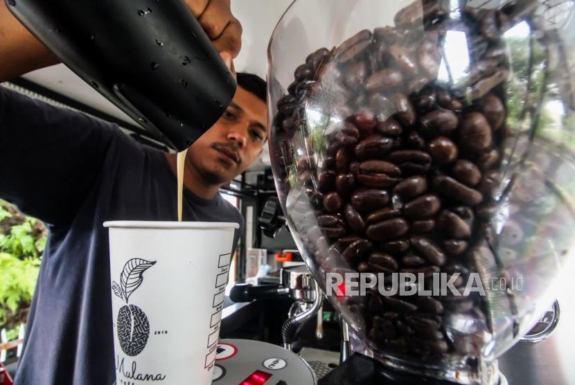 Pekerja meracik kopi pesanan pembeli di dalam mobil warung kopi kaki lima di Lhokseumawe, Aceh, Jumat (29/11/2019).