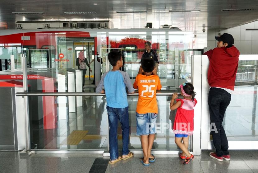 Penumpang bersiap menaiki kereta Light Rail Transit (LRT) di Stasiun Velodrome Rawamangun, Jakarta, Ahad (1/12).