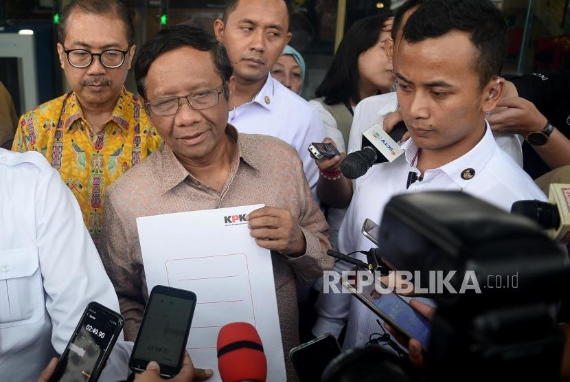 Menko Polhukam Mahfud MD (kanan) menjawab pertanyaan wartawan seusai menyerahkan Laporan Harta Kekayaan Penyelenggara Negara (LHKPN) di gedung KPK, Jakarta, Senin (2/12).